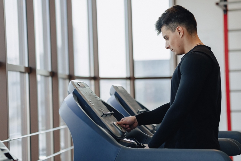 stylish guy in the gym is training on the treadmill. Healthy Lifestyle. wellness.